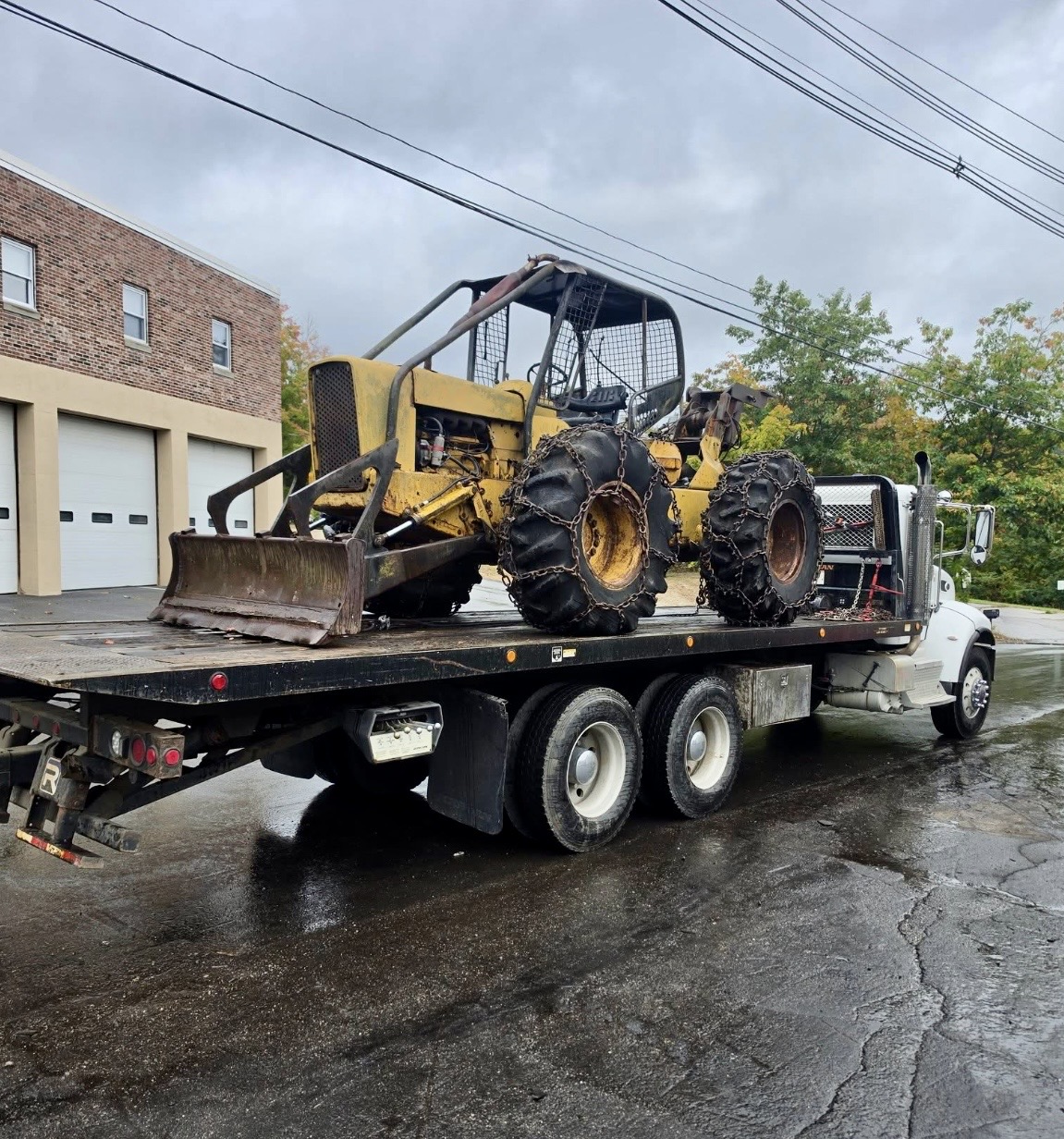 Vintage yellow log skidder on a truck deck