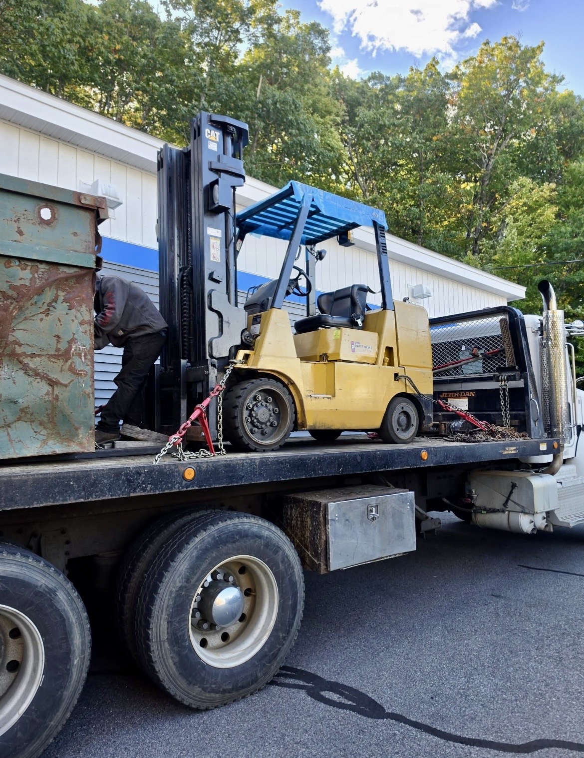 Caterpillar forklift chained to a truck flatbed