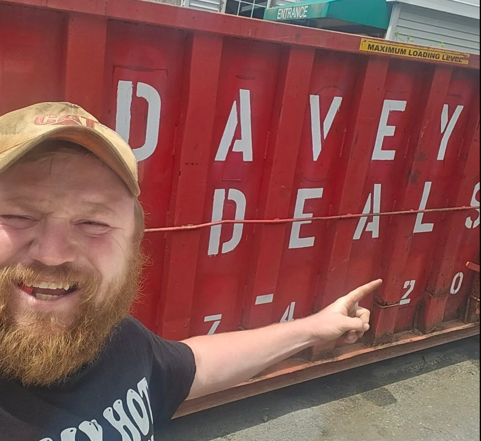 Dave Farnham, owner of Davey Deals, next to a Davey Deals dumpster